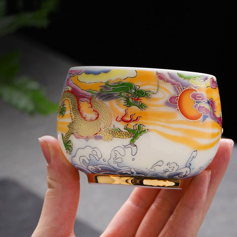 Dragon Phoenix Ceramic Teacup - Golden dragon cup cradled in hand with natural foliage, authentic
