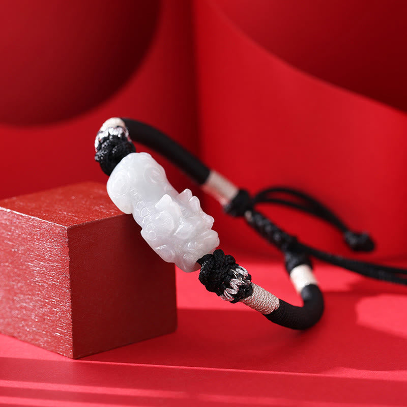 Natural Jade PiXiu Bracelet – side angle on red block, carved white jade detail, black cord, jade bracelet luck
