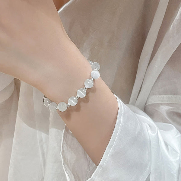 Cat's Eye PiXiu Bracelet – Wrist shot with white chiffon sleeve, delicate feminine jewelry style