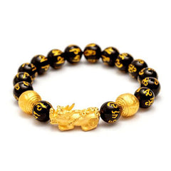 FengShui PiXiu Obsidian Wealth Bracelet - Three-quarter view on white, gold Pixiu charm center, obsidian wealth bracelet