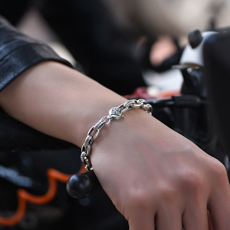 Om Mani Padme Hum Silver Bracelet – Worn on wrist near motorcycle, lifestyle shot showing silver chain with engraved links, mens bracelet