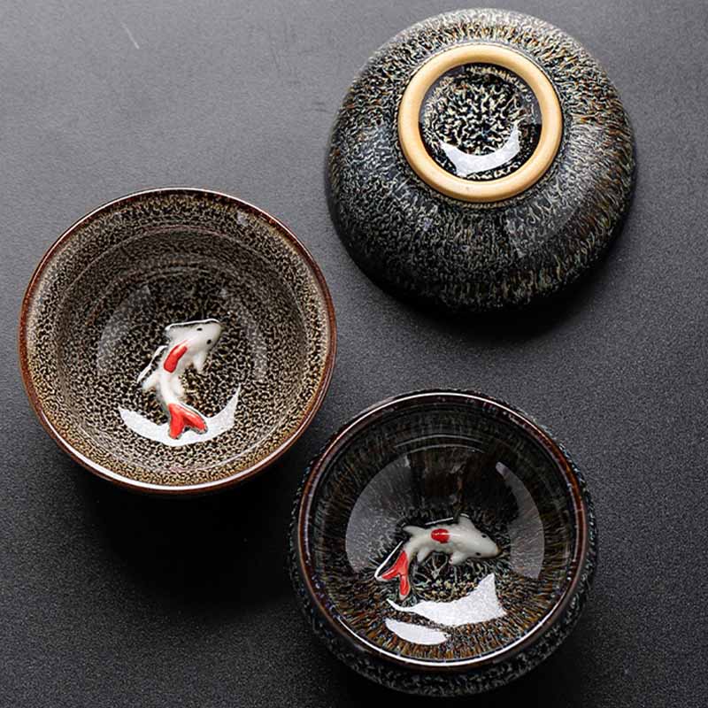 Jianzhan Koi Teacup – dark studio background highlighting vivid koi glaze, pottery art
