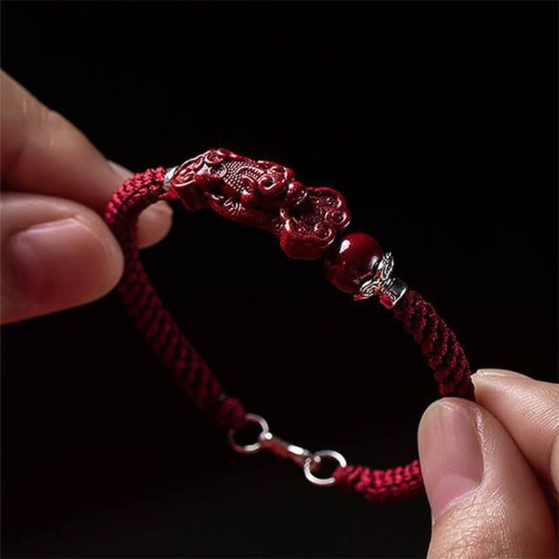 Handcrafted PiXiu Cinnabar Wealth Luck Braided Bracelet – close-up held against black background, detailed carving