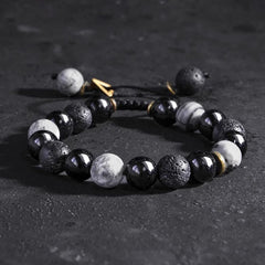 Black Obsidian Lava Rock Yin Yang Bracelet - angled close-up on dark stone, glossy and matte beads