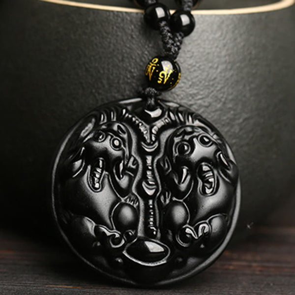 Double PiXiu Necklace – Black obsidian carved double PiXiu pendant against black ceramic cup, purification jewelry