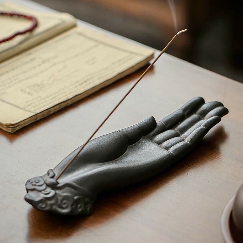 Buddha Hand Incense Burner – lit incense beside ancient calligraphy book and red prayer beads, traditional