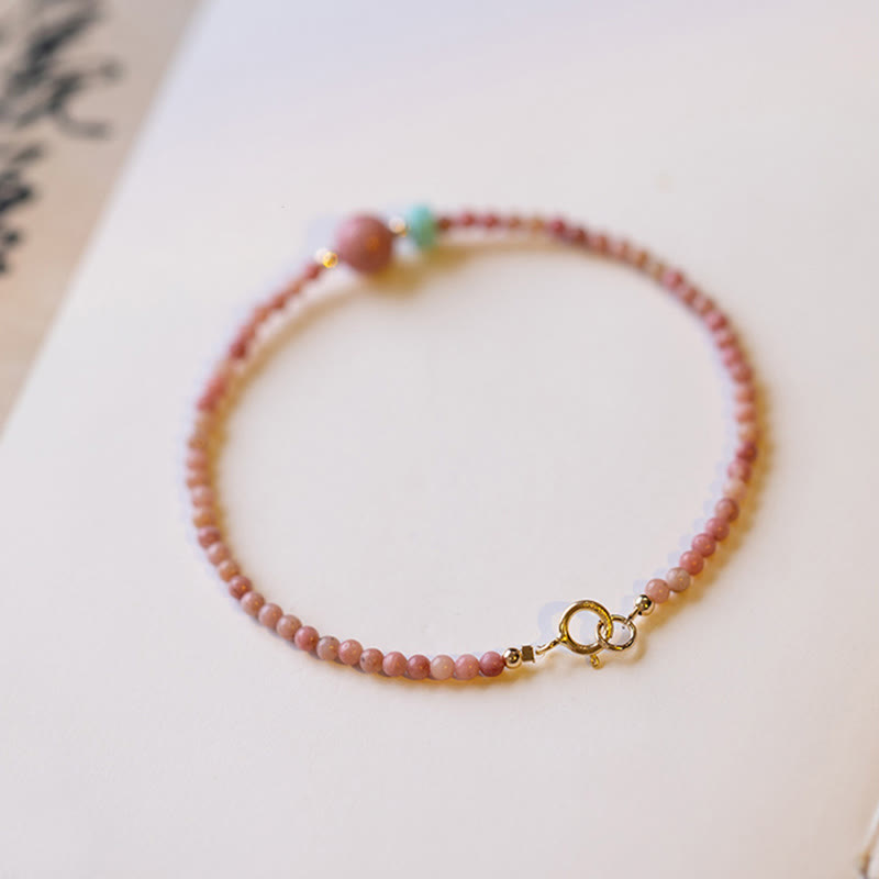 Rhodonite Loving Energy Bracelet – Pink-to-cream ombré stone beads with gold spring ring clasp and spacers on white background, soft bokeh