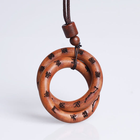 Qiankun Circle Necklace – White background hero shot of interlocking double-ring wooden pendant with burned Chinese seal scri