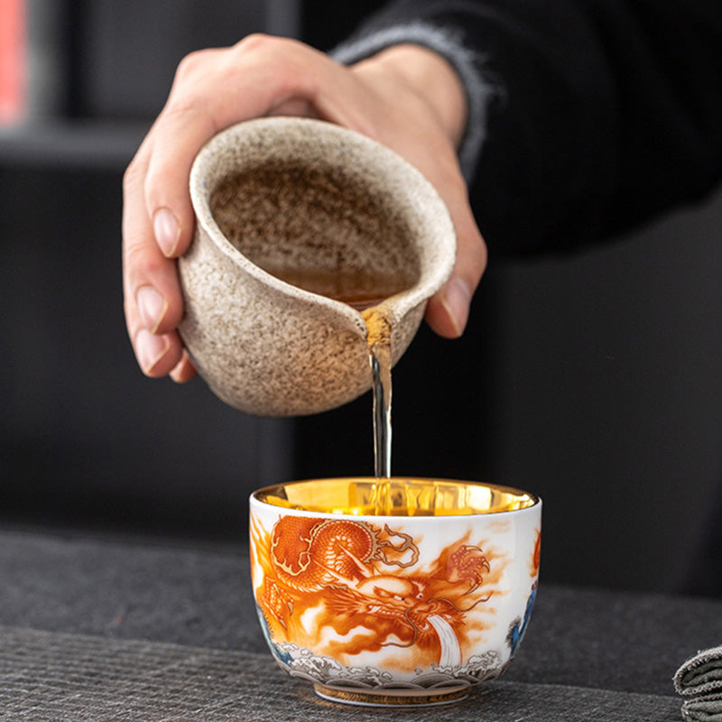 Dragon Phoenix Crane Gilt Ceramic Teacup – straight-on side view with orange dragon and wave motif, gold interior, white background