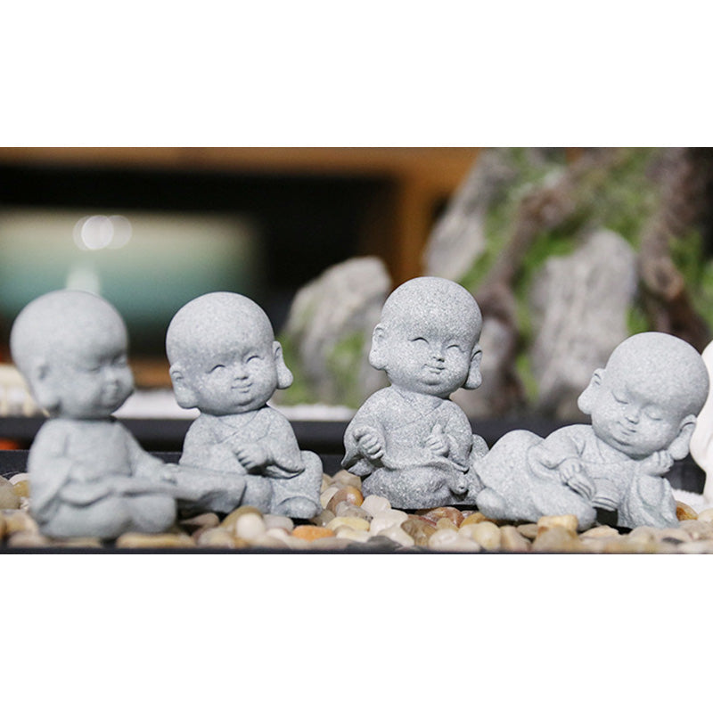 Meditation Monk Statue - Four monk figurines collection displayed on pebbles panoramic view