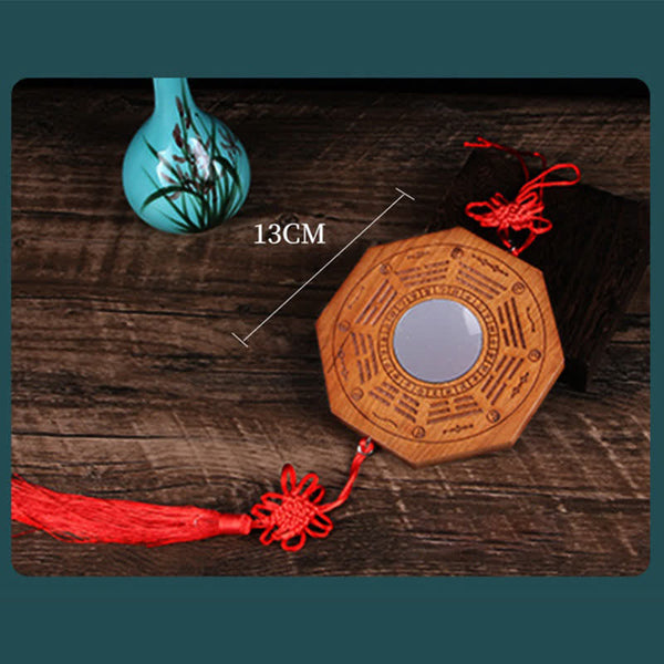 Peach Wood Bagua Map - octagonal mirror with concave center and red Chinese knots on teal bordered bg
