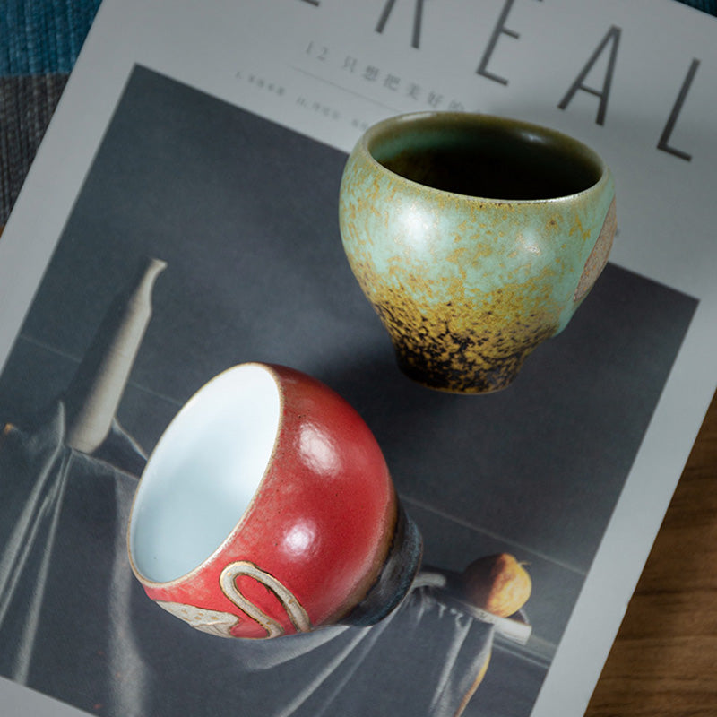 Lotus Pod Ceramic Kung Fu Tea Cup - Green and red glazed pair resting on magazine, wabi-sabi style