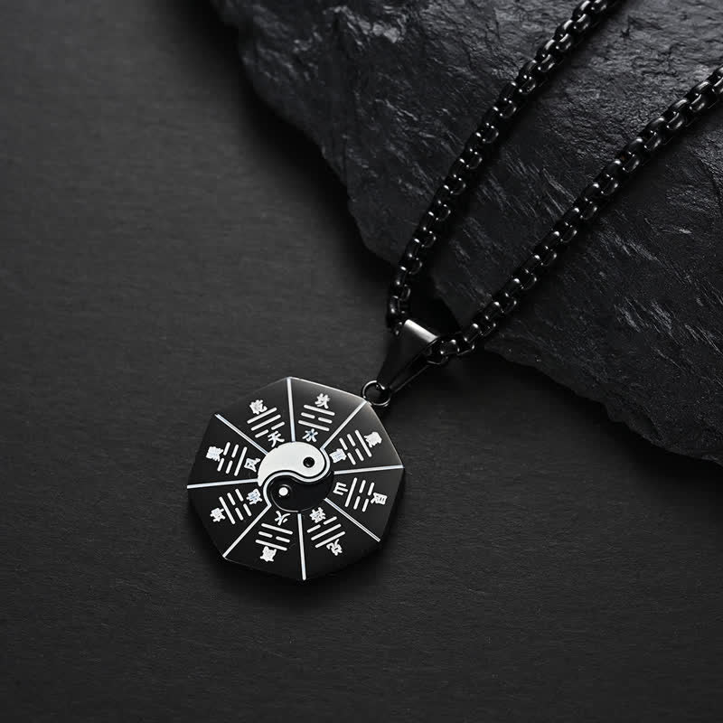 Bagua Yin Yang Titanium Steel Pendant - Black Bagua yin-yang medallion on dark stone, titanium steel jewelry