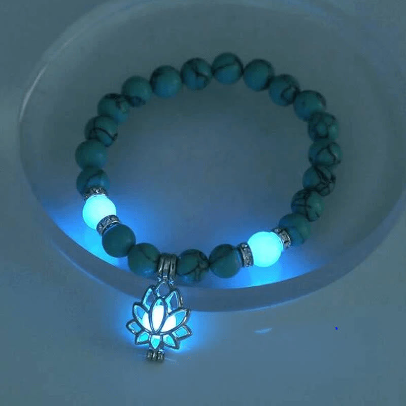 Tibetan Turquoise Glowstone Lotus Bracelet – turquoise beads with cyan glowing lotus pendant in dish, UV-lit, glowstone lotus