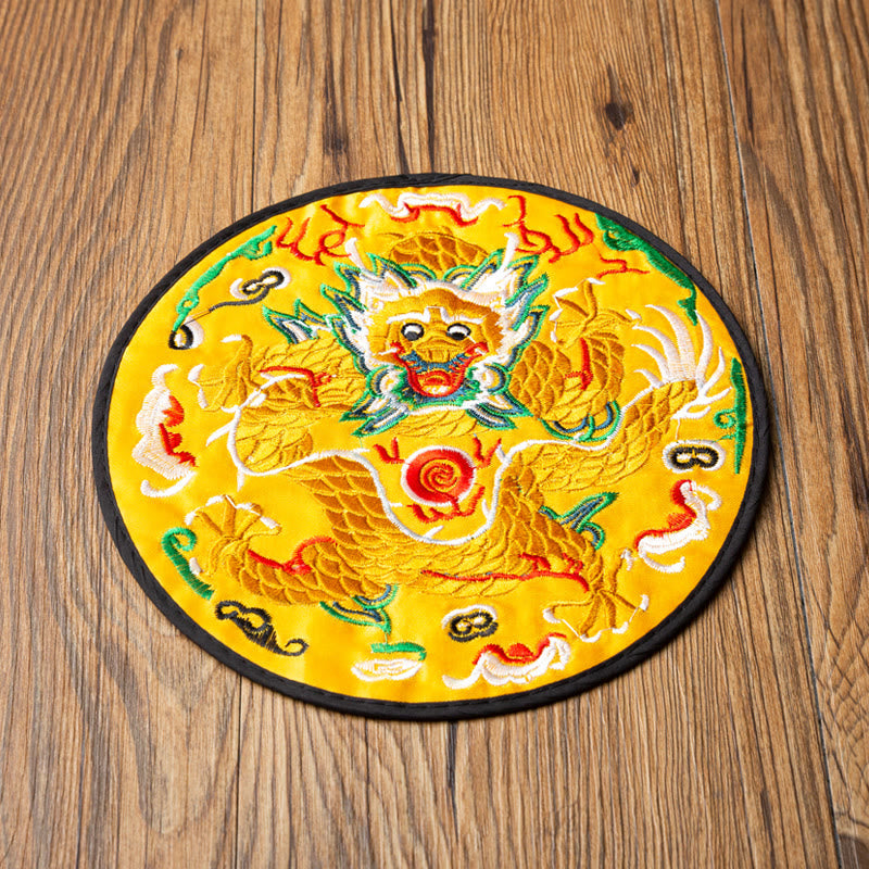 Dragon Embroidery Tea Cup Coaster Mat - yellow base with frontal coiled dragon top-down on wood, imperial symbolism