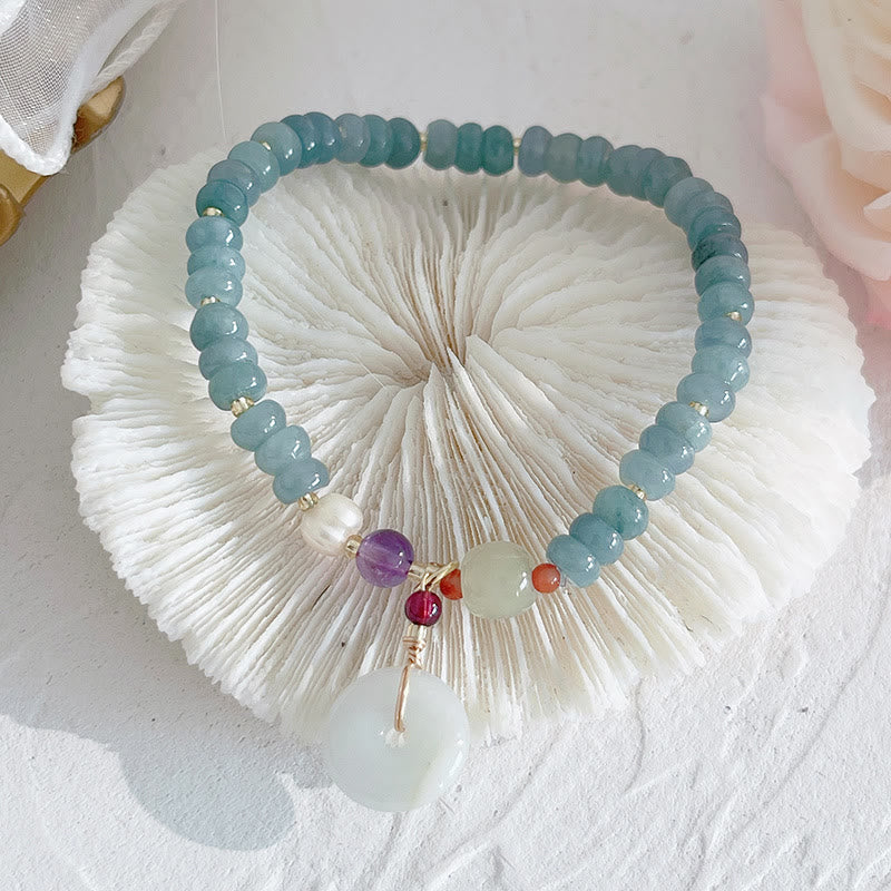 Hetian Jade Pearl Fu Gourd Money Bag Bracelet – Jade bracelet with disc and purple bead on glass plate, spiritual bracelet