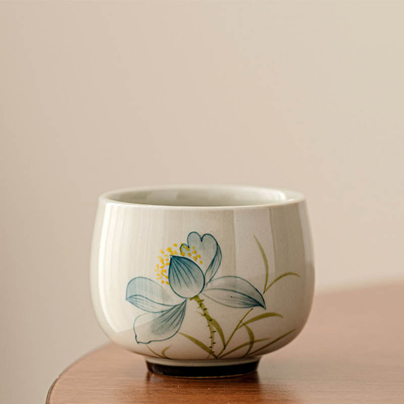 Hand Painted Lotus Tea Cup – rounded bowl form with blue lotus flower and yellow stamens, off-white, artisanal