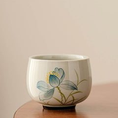 Hand Painted Lotus Tea Cup – rounded bowl form with blue lotus flower and yellow stamens, off-white, artisanal