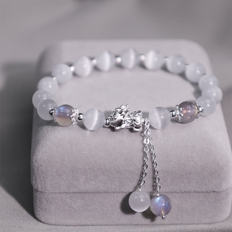 Cat's Eye PiXiu Bracelet – Close-up of silver PiXiu with chain tassels on plush gray jewelry box