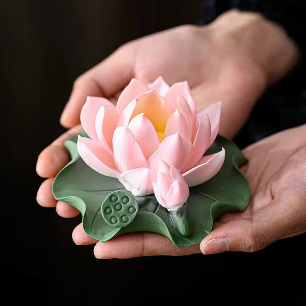 Lotus Ceramic Incense Burner - held in hands showing pink lotus on green leaf, black background, tea pet