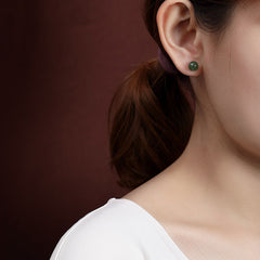 925 Silver Cyan Jade Healing Stud Earrings – deep green jade stud earring worn on model, burgundy background, lifestyle portrait shot