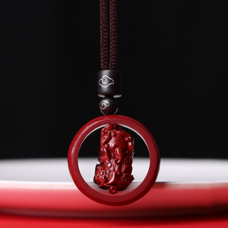 Cinnabar PiXiu Necklace – Black cord PiXiu carved pendant close-up on black background, feng shui protection charm