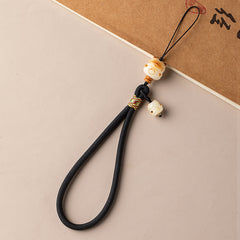 Bodhi Maneki Neko phone strap in black cord with Maneki Neko charm and woven knot