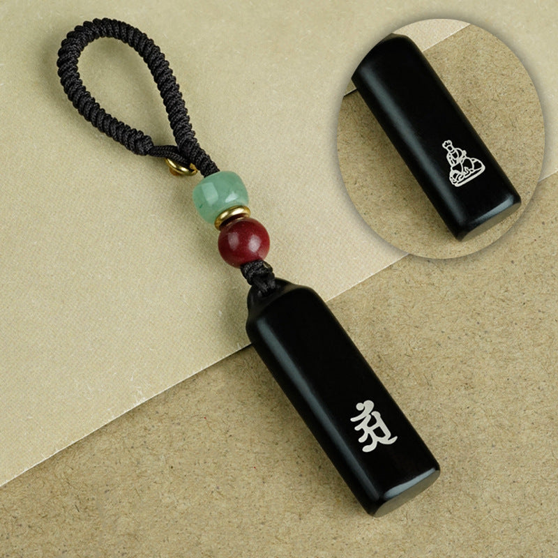 Eight ebony guardian talisman keychains collection display on black background with jade and cinnabar beads