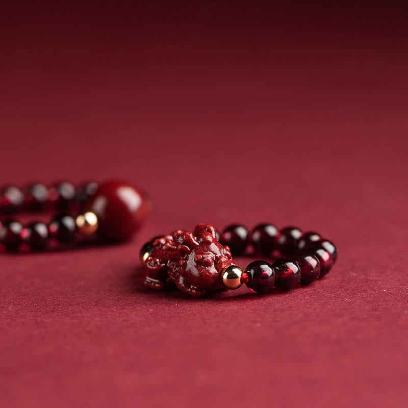 Garnet Cinnabar Ring – model finger cinnabar PiXiu ring close up red background, wealth charm