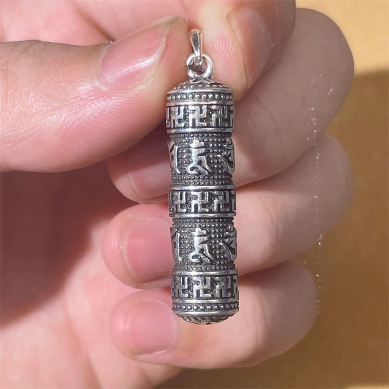 Copper Om Mani Padme Hum Necklace – Hand-held close-up of cylindrical pendant showing carved swastika borders and Sanskrit mantra bands, oxidized silver spiritual jewelry