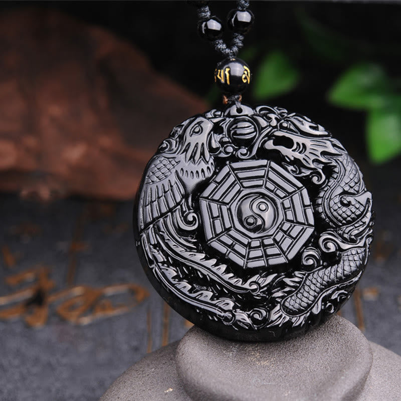 Bagua Dragon Phoenix Obsidian Pendant – Front view on stone pedestal with gold calligraphy, balanced