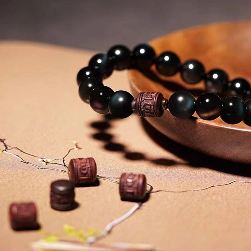 Gold Sheen & Rainbow Obsidian Fu Bracelet – styled with plum blossoms on warm surface, artisan jewelry