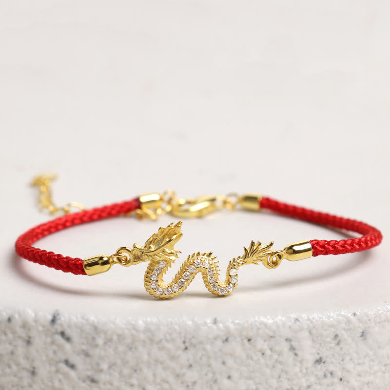 925 Silver Dragon Bracelet - Crystal dragon on red cord over white marble, protected talisman