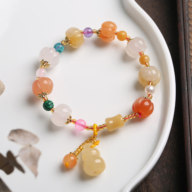 Golden Silk Jade Gourd Bracelet – Multi-color jade bracelet on white ceramic dish