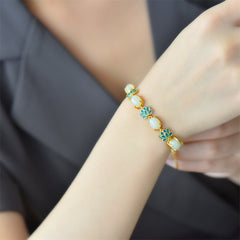 White Cyan Jade Lotus Bracelet - Worn on wrist over dark clothing, jade and cyan lotus, lifestyle spiritual