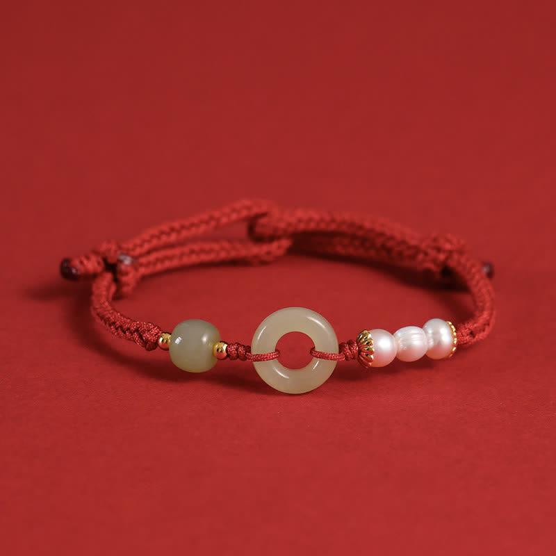Hetian Jade Pearl Peace Buckle Bracelet – red cord adjustable bracelet with jade bi disc and pearls, red background elevated side view