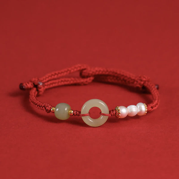 Hetian Jade Pearl Peace Buckle Bracelet – red cord adjustable bracelet with jade bi disc and pearls, red background elevated side view