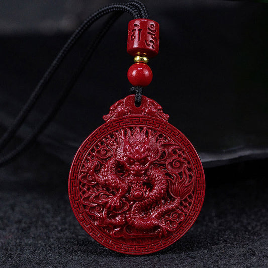 Vermilion red cinnabar dragon pendant necklace with carved Chinese dragon medallion, black cord and gold accent bead on dark background