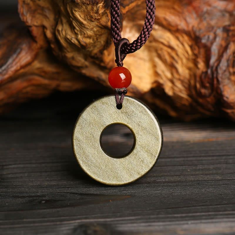 Peace Buckle PiXiu Necklace – Smooth gold sheen obsidian disc back with red bead against wood, protection pendant