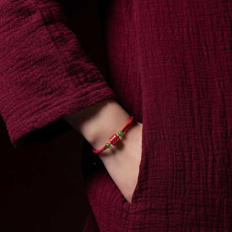 Tibetan Cinnabar Braided Rope Bracelet – Worn on wrist with burgundy outfit, lifestyle fit demonstration