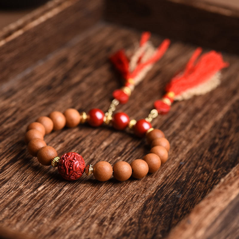 Peach Wood PiXiu Wealth Bracelet – Wooden beads with carved cinnabar and tassels on dark wood, luck jewelry