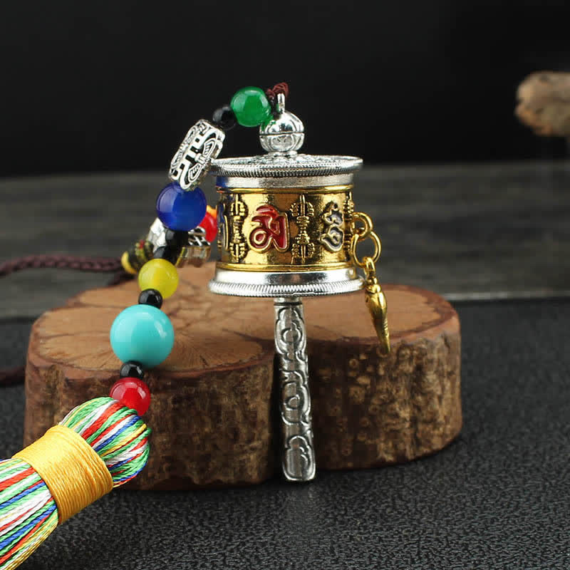 Tibetan Prayer Wheel Tassel – Miniature prayer wheel with silk tassel and beaded cord on wood stand