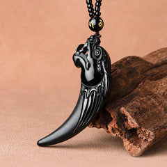 Black Jade Dragon Tooth Pendant – three-quarter view on natural wood, carved dragon head detail, spiritual talisman