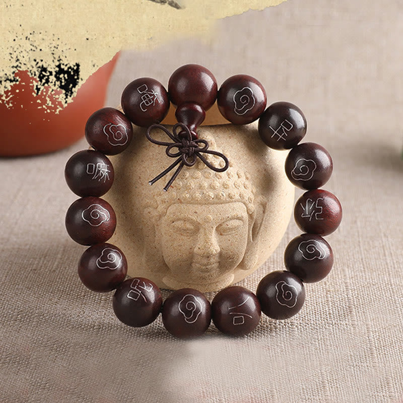 Sterling Silver Sandalwood Mantra Bracelet – resting on Buddha head sculpture, spiritual meditation accessory