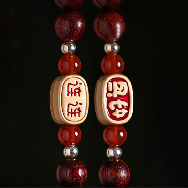Red Sandalwood Car Hanging – Polished red sandalwood beads with natural wood grain in shallow focus, sandalwood prayer beads