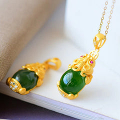 Natural Jade Pixiu Necklace – two green jade Pixiu pendants on white book, protection luck