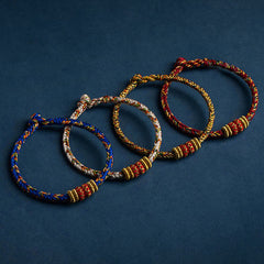 Set of four handmade braided cord bracelets in blue cream gold and red, with red gold accent beads, adjustable knot closure spiritual protection jewelry
