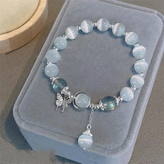 Cat's Eye Moonstone Butterfly Bracelet – Pale blue cat's eye beads with silver butterfly crystal charm and iridescent accent beads on gray velvet cushion display