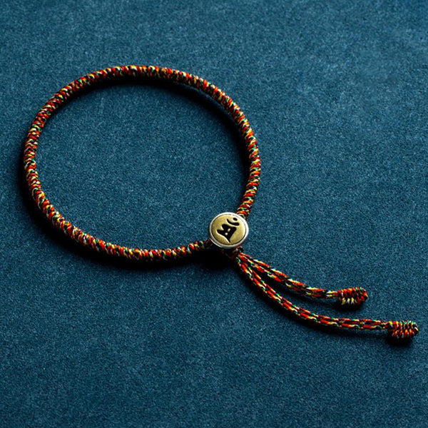 Braided cord bracelet with engraved bead, flat lay