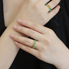 18K Gold Green Chalcedony Strength Ring – Two green jade filigree rings worn on crossed hands with natural nails, black fabric background, elevated diagonal